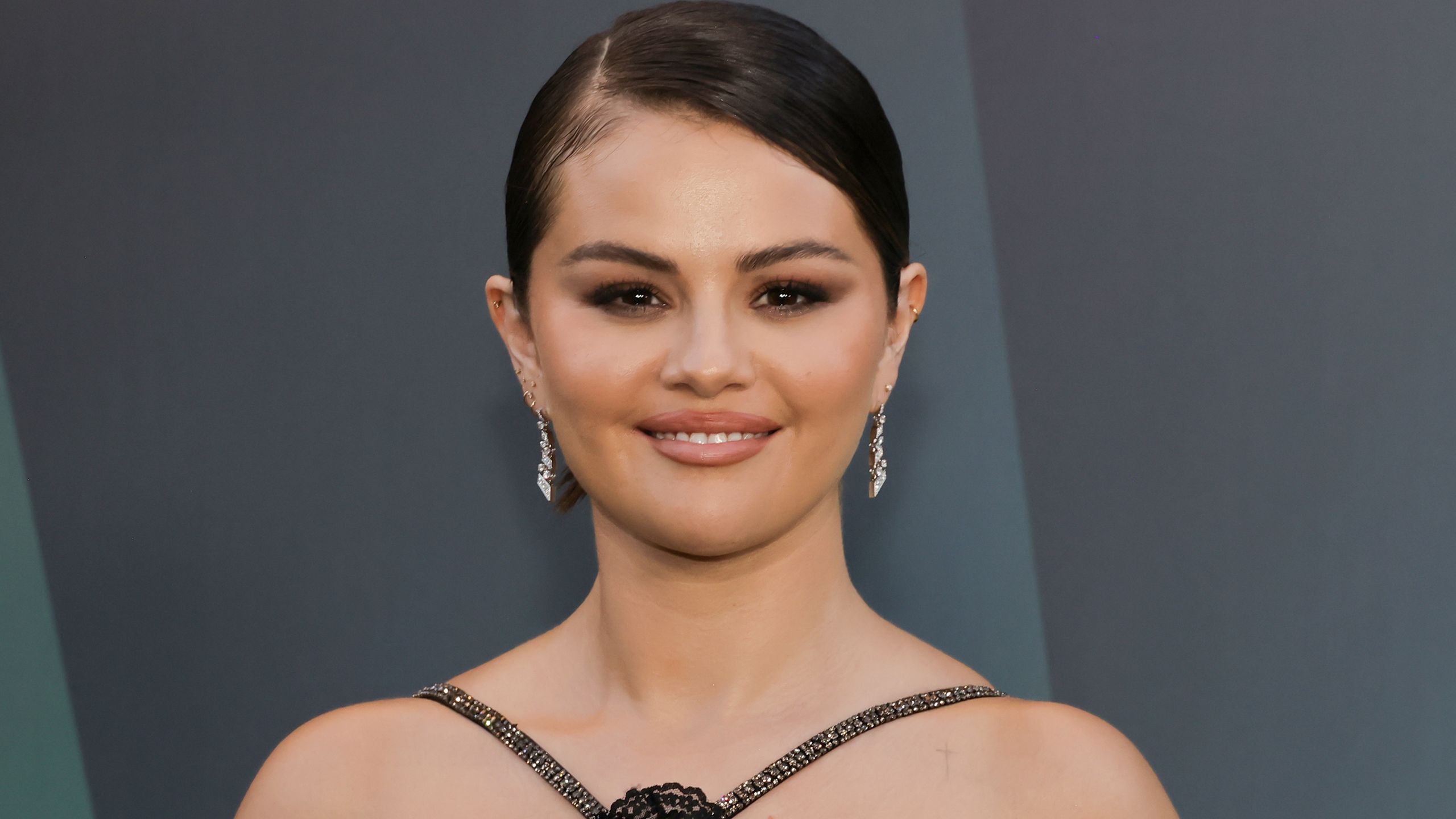 Selena Gomez appears at an event in a black dress and a sleek bob.