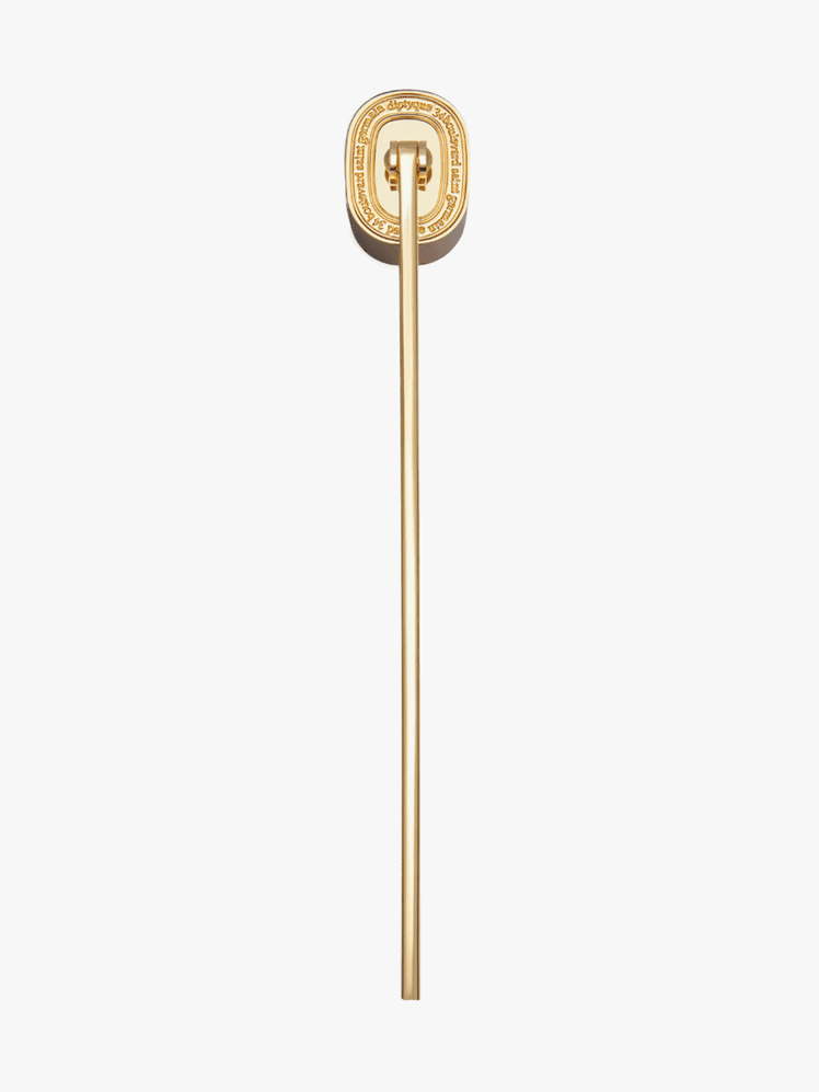 Diptyque Candle Snuffer in gold branded component on a light gray background